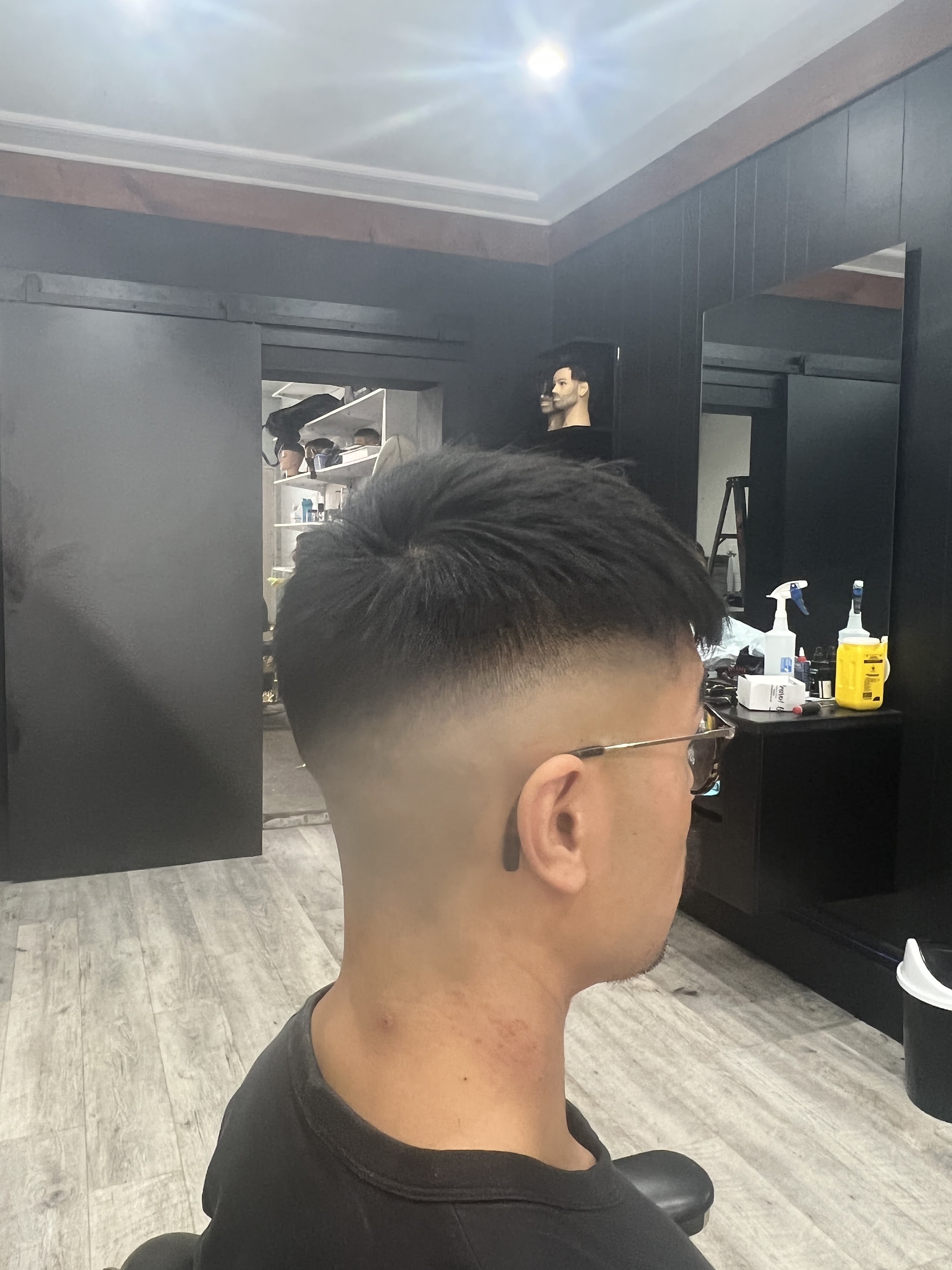 A finished textured mid fade, seen from behind in the shop